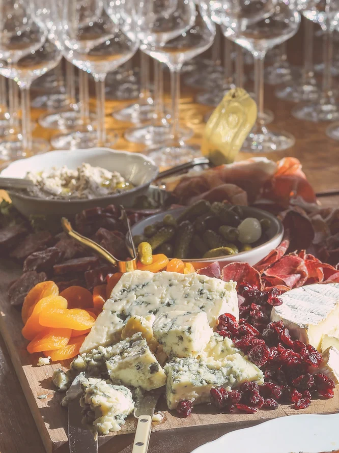 Vinglas och ostbricka med chark och godsaker uppställt för mingel